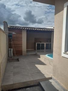 a house with a patio and a swimming pool at Casa com 03 Quartos, Piscina e Churrasqueira em Itaipuaçu Maricá RJ in Maricá