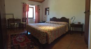 1 dormitorio con cama, mesa y ventana en Podere Pinzicalari, en Castel del Piano
