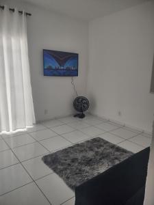 a white room with a television on a wall at Casa com 03 Quartos, Piscina e Churrasqueira em Itaipuaçu Maricá RJ in Maricá +31 photos