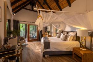 a bedroom with a bed with a white canopy at Karongwe - Kuname Safari Lodge in Hoedspruit +199 photos