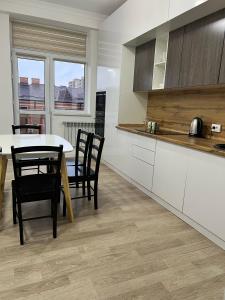 a kitchen with a table and chairs and a dining room at ЖК Green Plaza Aktau Двухкомнатная большая in Aktau