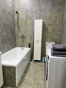a bathroom with a tub and a toilet and a sink at ЖК Green Plaza Aktau Двухкомнатная большая in Aktau