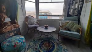a living room with a table and chairs and a window at Susies zen den by the sea in Swanage