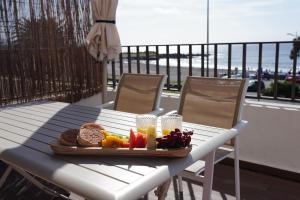 a tray of food on a table on a balcony at 3 balconies with sea view - restaurants below - personalized support - Ponta Delgada -DOMOSTAY AL in Ponta Delgada