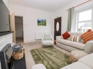 ein Wohnzimmer mit Sofa und Fernseher in der Unterkunft Cosy Cottage in Cumbria, West of Lake District in Broughton Moor