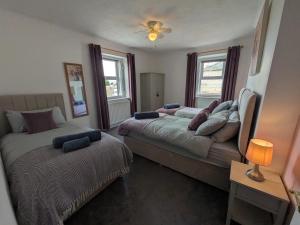 ein Schlafzimmer mit zwei Betten und einer Couch in der Unterkunft Cosy Cottage in Cumbria, West of Lake District in Broughton Moor