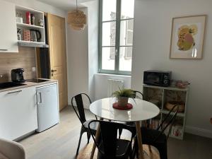 a kitchen with a table and chairs in a room at Joli petit appartement plein centre in Chalon-sur-Saône