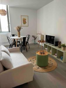 a living room with a couch and a table at Joli petit appartement plein centre in Chalon-sur-Saône