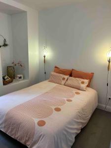 a bedroom with a large bed with two lights at Joli petit appartement plein centre in Chalon-sur-Saône