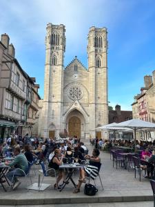 a group of people sitting at tables in front of a church at Joli petit appartement plein centre in Chalon-sur-Saône