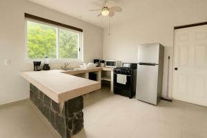 a kitchen with a white refrigerator and a stove at 2 Rec Vista a las Montañas I Amplia Terraza I Smart TV-Netflix I Wi-Fi I Recién Remodelado in Ixtapa
