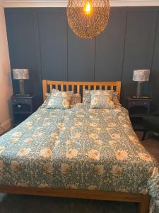 a bed in a bedroom with two night stands and two lamps at Old Store Cottage, Up Holland in Upholland +29 photos