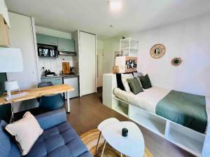 a bedroom with a bed and a blue couch at Ho Toulouse -Joli studio avec balcon in La Celle-sous-Gouzon