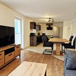 a kitchen and living room with a table and chairs at Moritz Apartments - Pfarrgasse 09 in Küllstedt