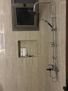 a bathroom with a shower with a tv on the wall at شقة بحي البرج جديدة in Al Kharj