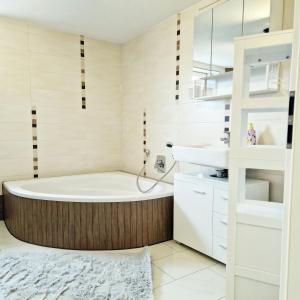 a bathroom with a tub and a sink at Moritz Apartments - Wohnung 15 in Küllstedt