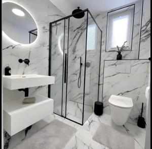 a white bathroom with a sink and a toilet at Cozy Getaway apartment in Ibadan