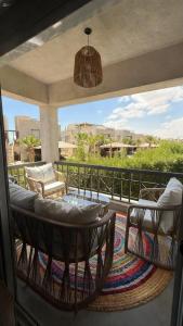 a patio with two chairs and a couch on a balcony at Cozy 2BRs chalet in Einbay Boho designed in Ain Sokhna