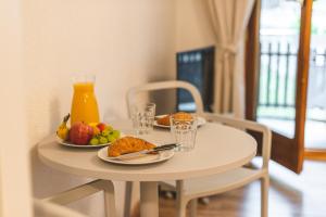 un tavolo con due piatti di cibo e una brocca di succo d'arancia di Zermatt - well located and equipped studio a Zermatt