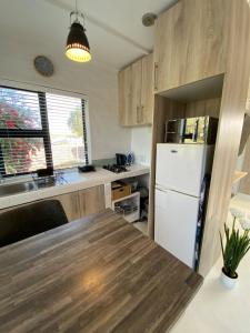 a kitchen with wooden cabinets and a white refrigerator at Quilla Quarters in Plumstead