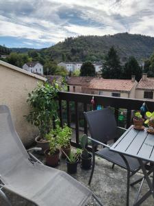 a table and a chair on a balcony with plants at Appartement près du centre in Cahors