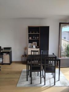 a dining room with a black table and chairs at Appartement près du centre in Cahors +7 photos