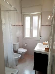 een witte badkamer met een toilet en een wastafel bij Domus 1 in Negrar