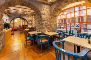 a restaurant with wooden tables and blue chairs at Amerindia in Cusco