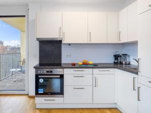 a kitchen with white cabinets and a stove at Modern City Apartment near Vienna Central Station in Vienna