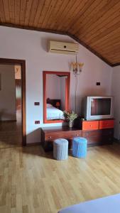 a bedroom with a bed and a television and stools at Eni's Villa, 5km From Shengjini Beach in Lezhë