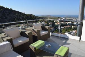 a balcony with chairs and a table with a view at Panorama Penthouse & Studios in Athens