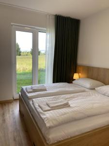 a bedroom with a large bed with a large window at Malé Lipno Apartment 225-7 Lipno Home in Černá v Pošumaví