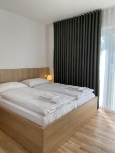 a bed in a bedroom with a large window at Malé Lipno Apartment 225-7 Lipno Home in Černá v Pošumaví