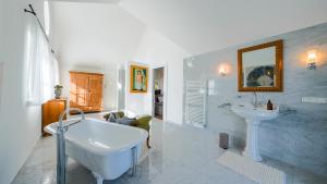 a white bathroom with a tub and a sink at Villa Victoria in Fischerndorf +107 photos