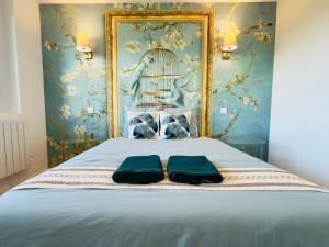 a bedroom with a bed with a bird cage and two towels at Appartement spacieux et lumineux - 10 personnes - entre lacs et montagnes in Fillinges