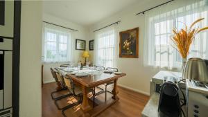 a dining room with a table with chairs and windows at Villa Victoria in Fischerndorf