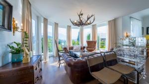a living room with a couch and chairs and windows at Villa Victoria in Fischerndorf