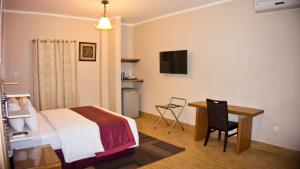 una camera d'albergo con letto e scrivania con computer di Tropical Enclave Hotel a Accra
