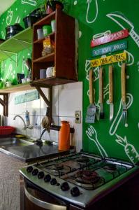 een keuken met een fornuis en een groene muur bij Quarto Golfinhos - Masculino in Pipa