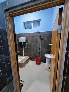 a bathroom with a shower and a toilet and a sink at DTM Homestay 2 in Tanah Merah +10 photos