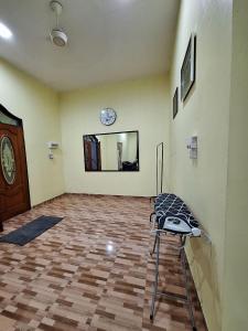 a room with a mirror and a chair in it at DTM Homestay 2 in Tanah Merah