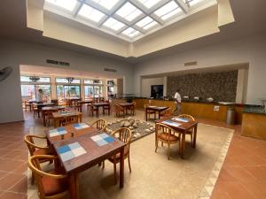 a dining room with tables and chairs and a large window at Badawia Sharm Resort in Sharm El Sheikh