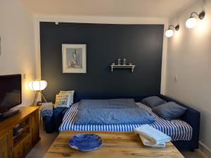 a bedroom with a blue bed and a table at Birkevang holiday apartment in idyllic countryside in Faxe