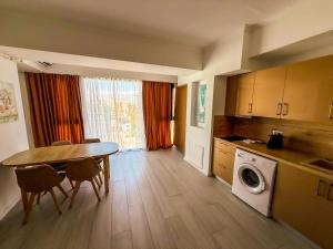 a kitchen with a table and a washing machine at Maritimo ApartHotel in Constanţa