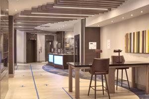 a lobby with a table and chairs and a staircase at Holiday Inn Express Vancouver-Metrotown (Burnaby) in Burnaby