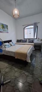 une chambre avec un grand lit et une fenêtre dans l'établissement Brachil 1, à Búzios