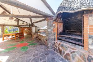 an outdoor brick oven with a table and a bench at Los Penones Experiences A - Solo Adultos in El Sao