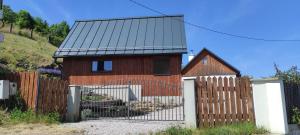 una casa con una valla de madera y una puerta en Pod farárovou hôrkou, en Banská Štiavnica 2 fotos más