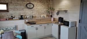 Una cocina con gabinetes blancos y un reloj en la pared. en Pod farárovou hôrkou, en Banská Štiavnica