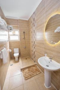 a bathroom with a sink and a shower and a toilet at Settle Inn South 90 Apartments in Cairo
